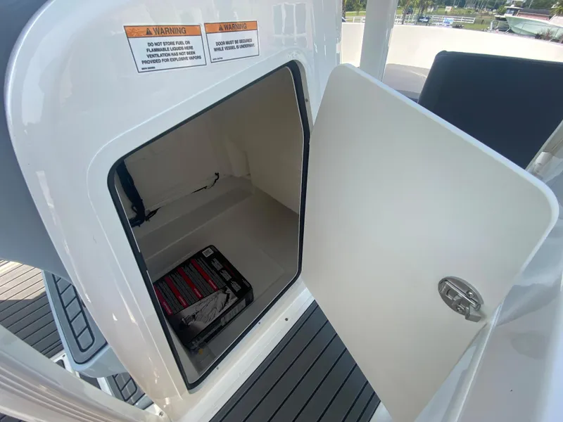 Slide: The Image of 2024 Bayliner Trophy 20 CC storage compartment with open door. - 21