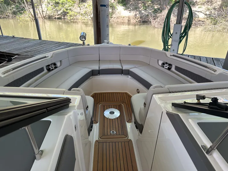 Slide: The Image of 2023 Sea Ray SLX 310 OB boat interior with teak flooring and cushioned seating. - 11