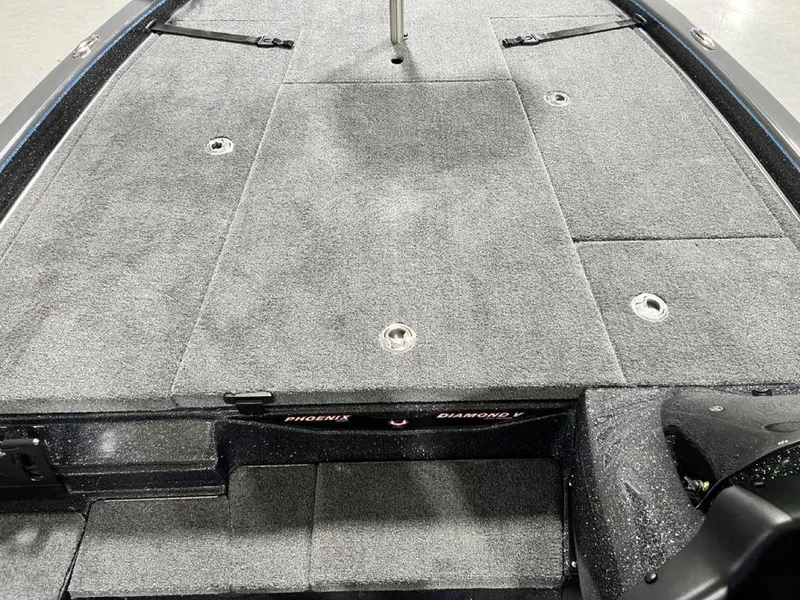 Slide: The Image of 2024 Phoenix 920 Elite boat deck with gray carpet and storage compartments. - 12