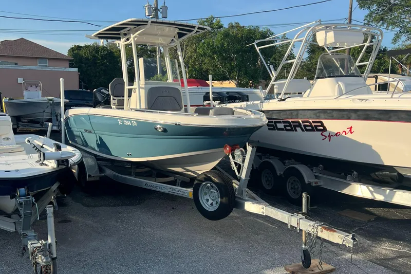 Slide: The Image of 2020 Stingray 216 CC boat on a trailer in a parking lot. - 10
