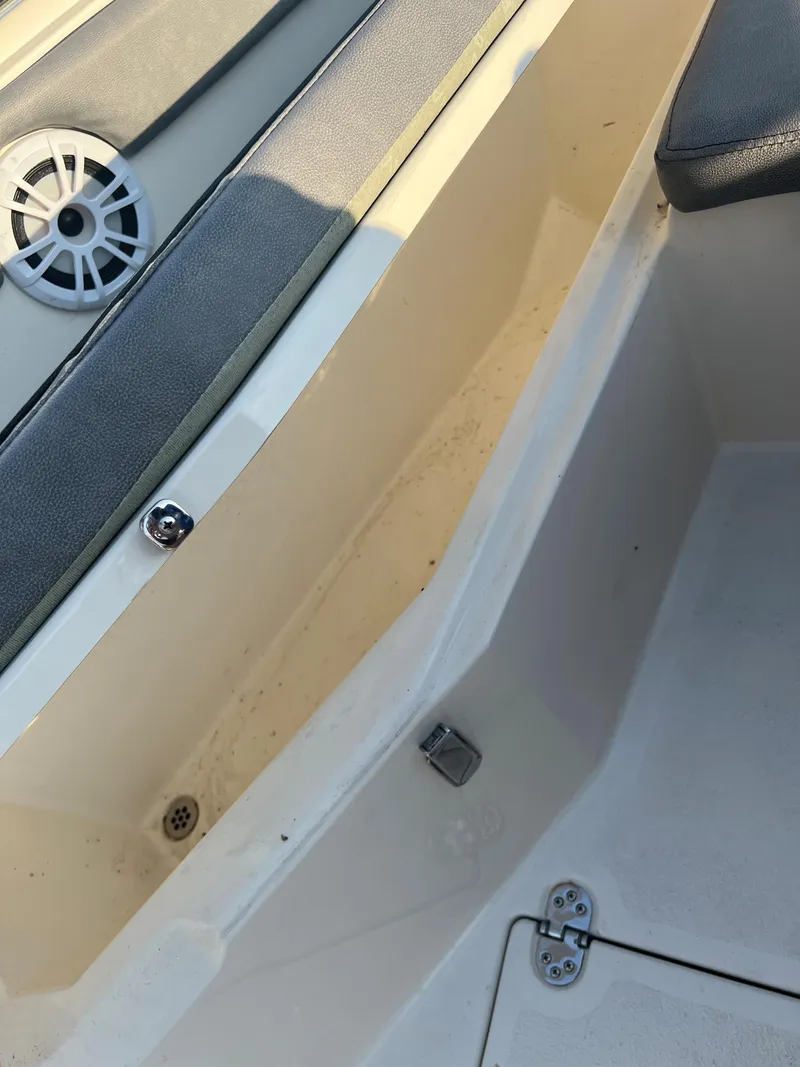Slide: The Image of 2020 Stingray 216 CC boat interior showing storage compartment and speaker. - 15
