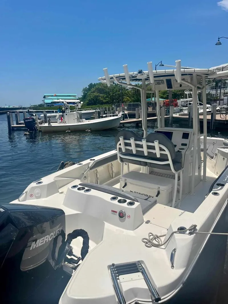 Slide: The Image of 2020 Stingray 216 CC boat docked at marina with Mercury outboard motor. - 2