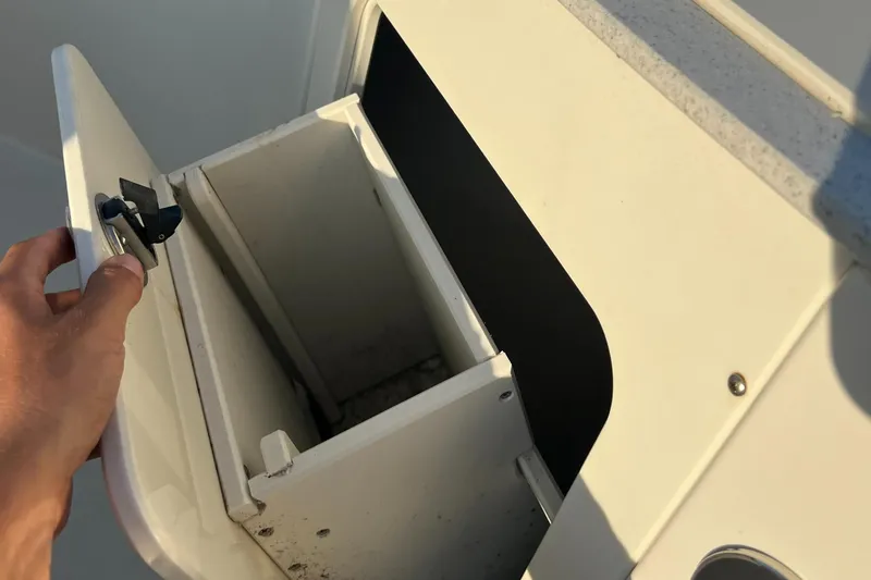 Slide: The Image of Hand opening storage compartment on 2020 Stingray 216 CC boat. - 29