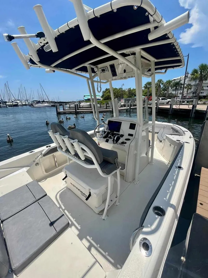 Slide: The Image of 2020 Stingray 216 CC boat docked at marina with T-top and dual console. - 3