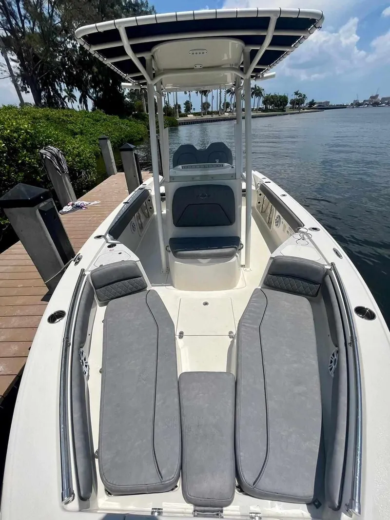 Slide: The Image of 2020 Stingray 216 CC boat docked by the water, featuring spacious seating and a T-top. - 33