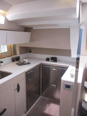 Slide: The Image of Modern kitchen area in the 2024 Jeanneau 55 yacht with sleek cabinetry and stainless steel appliances. - 27