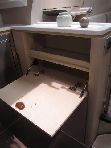 Slide: The Image of 2024 Jeanneau 55 yacht interior with open wooden storage compartment. - 32