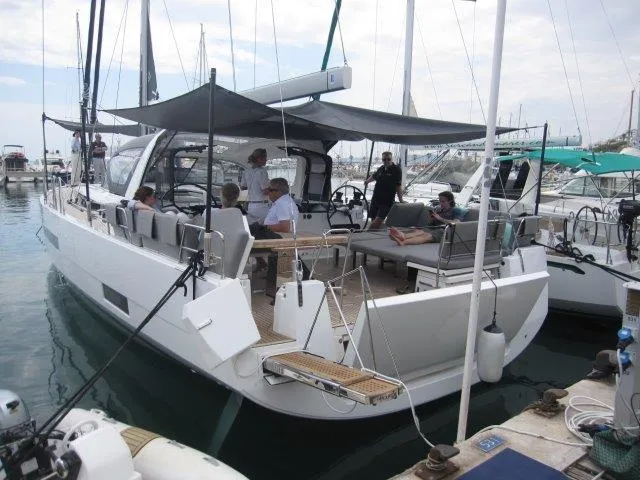 Slide: The Image of 2024 Jeanneau 55 sailboat docked with people onboard. - 6
