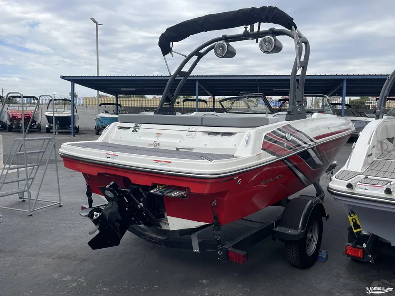Slide: The Image of 2023 Bayliner VR4 boat, red and white, on trailer in marina. - 3