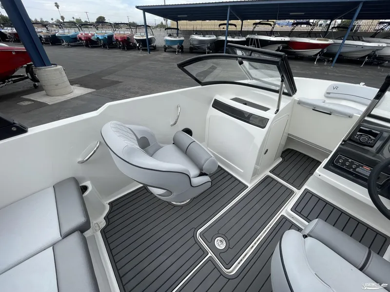Slide: The Image of 2023 Bayliner VR4 boat interior with modern seating and sleek dashboard design. - 7