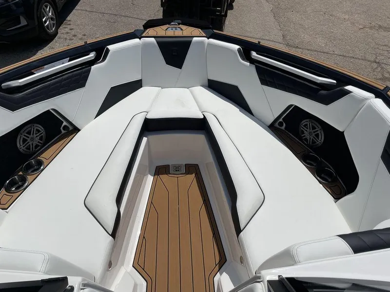 Slide: The Image of 2023 Nautique Super Air Nautique S25 boat interior with white seating and teak flooring. - 4