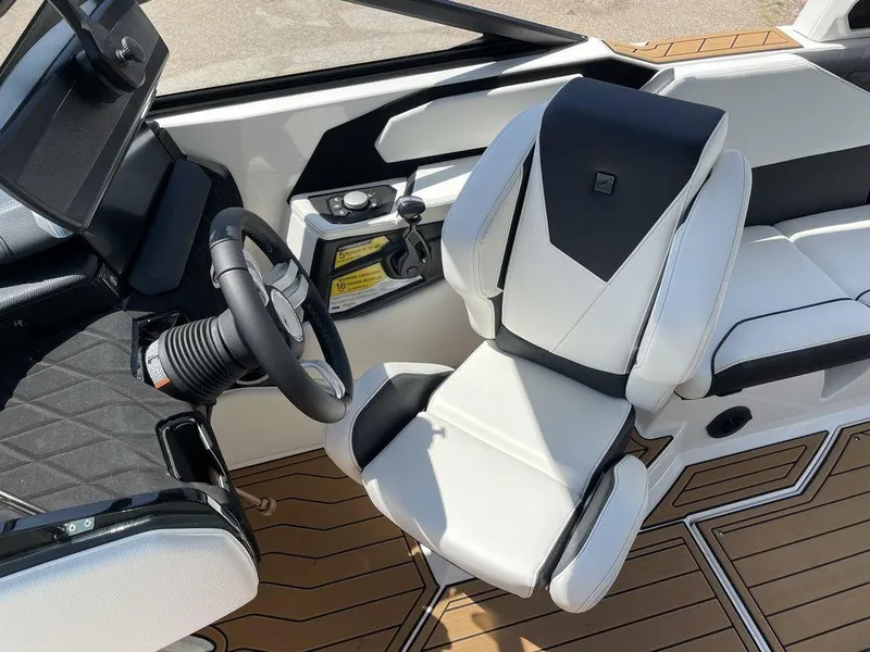 Slide: The Image of 2023 Nautique Super Air Nautique S25 boat interior with steering wheel and captain's chair. - 5