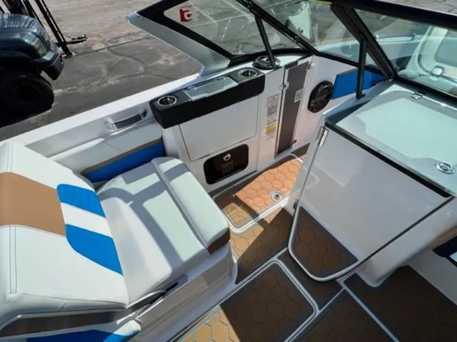 Slide: The Image of 2022 MasterCraft X26 boat interior with white, blue, and brown seating. - 13