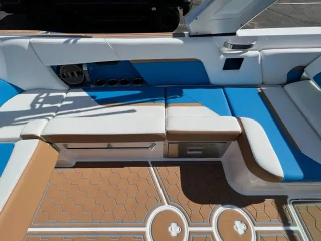 Slide: The Image of 2022 MasterCraft X26 boat interior with blue and white seating and hexagonal floor design. - 14