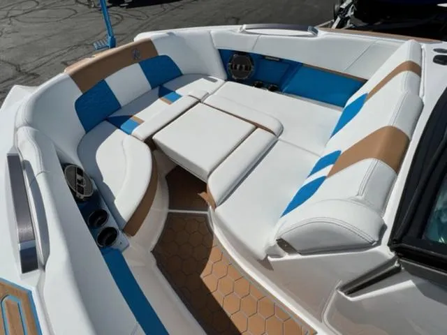 Slide: The Image of 2022 MasterCraft X26 boat interior with white, blue, and tan seating. - 19