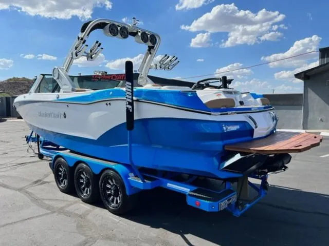 Slide: The Image of 2022 MasterCraft X26 boat on a trailer under a sunny sky. - 8