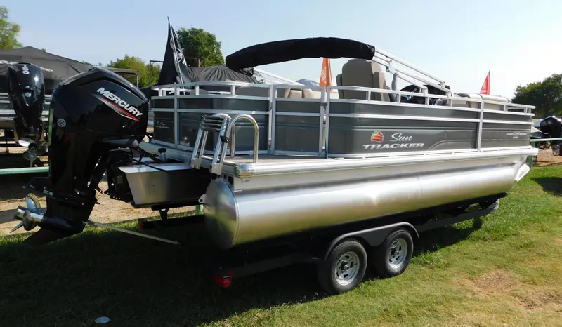 Slide: The Image of 2024 Sun Tracker Fishin' Barge 20 DLX pontoon boat on trailer with Mercury outboard motor. - 3