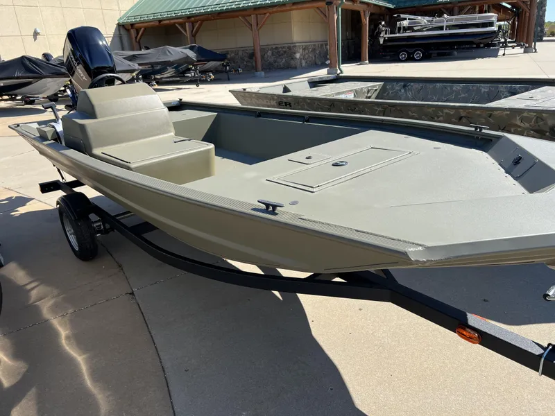 Slide: The Image of 2024 Tracker Grizzly 1648 SC fishing boat on trailer in outdoor showroom. - 2
