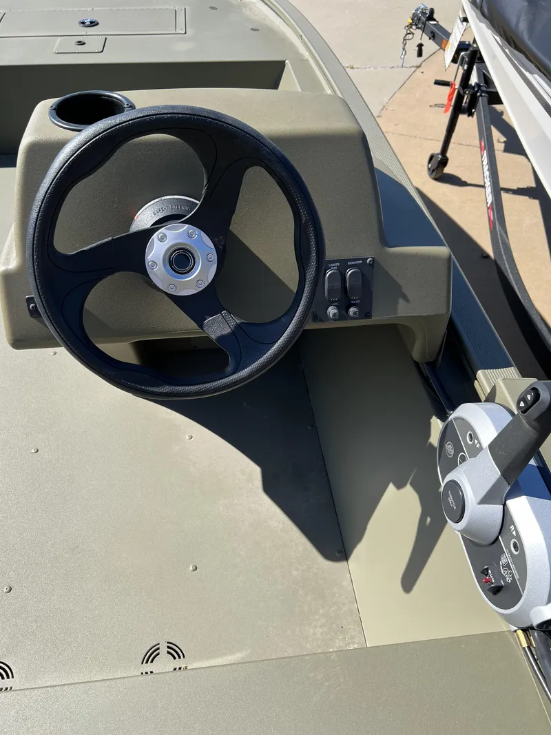 Slide: The Image of 2024 Tracker Grizzly 1648 SC steering console and throttle controls. - 5