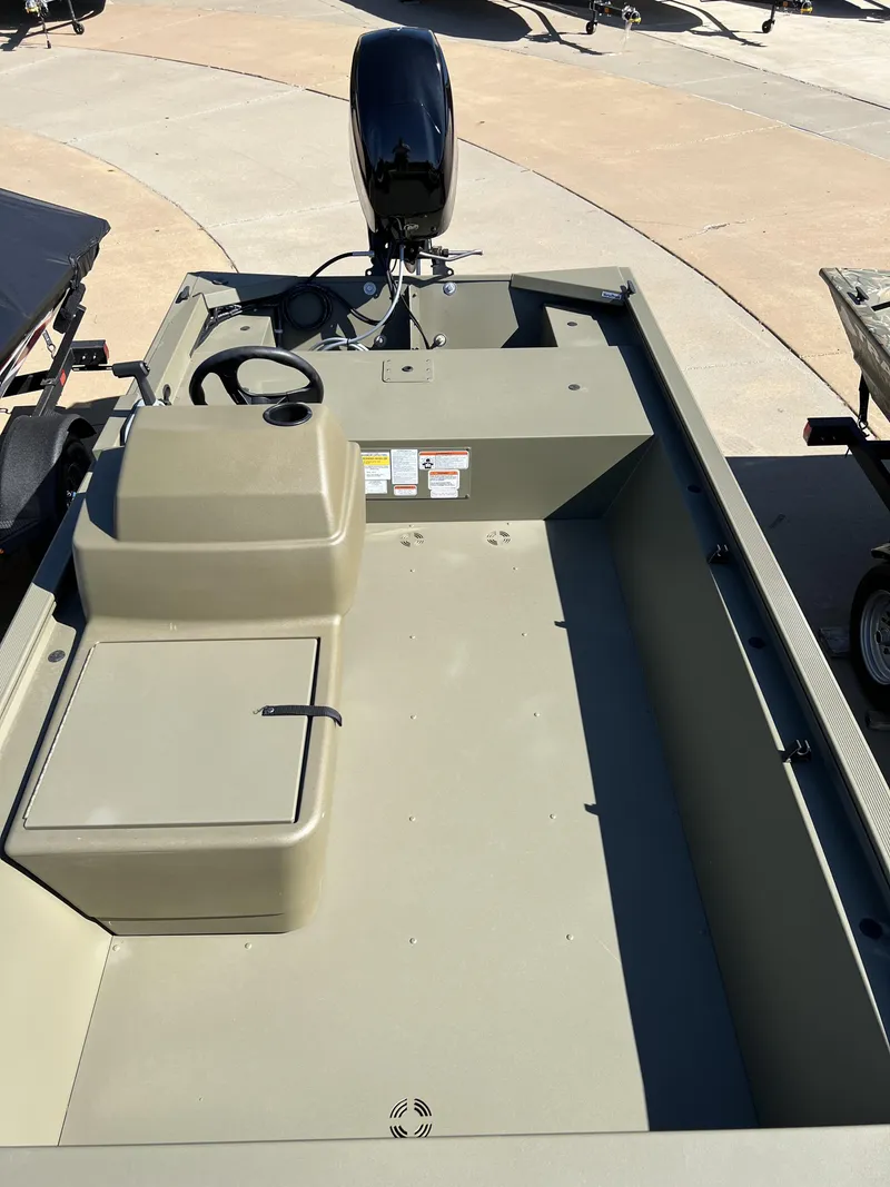 Slide: The Image of 2024 Tracker Grizzly 1648 SC boat with outboard motor, spacious interior, and storage compartments. - 7
