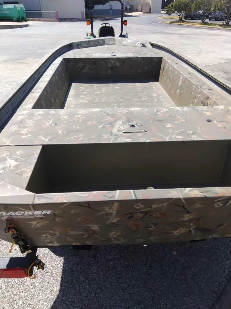 Slide: The Image of 2024 Tracker Grizzly 1754 Jon boat with camouflage design, empty interior view. - 2