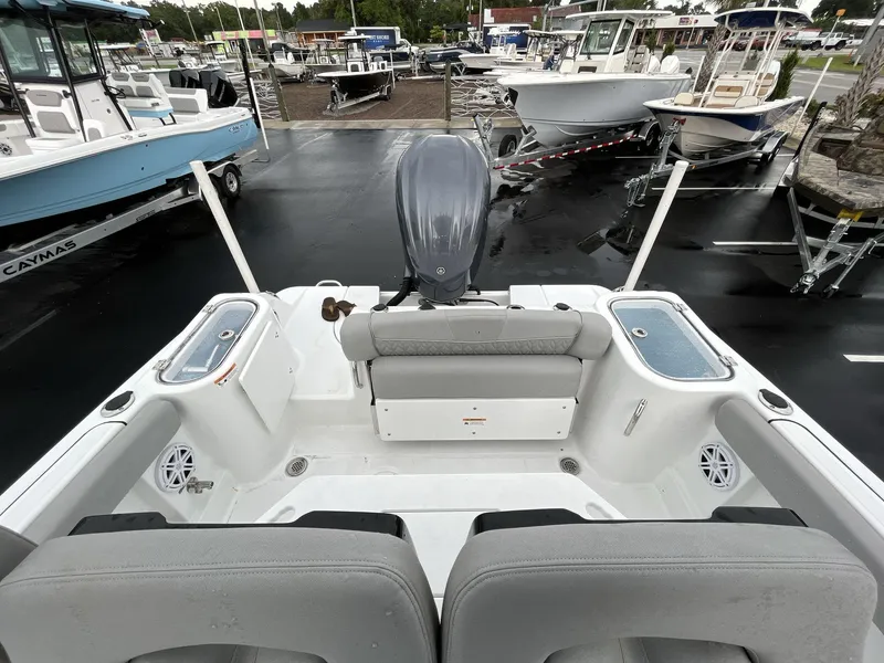 Slide: The Image of 2023 Wellcraft 242 Fisherman boat interior with motor, docked among other boats. - 6