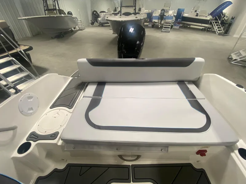 Slide: The Image of 2024 Bayliner Element M19 boat interior with cushioned seating in a showroom. - 10