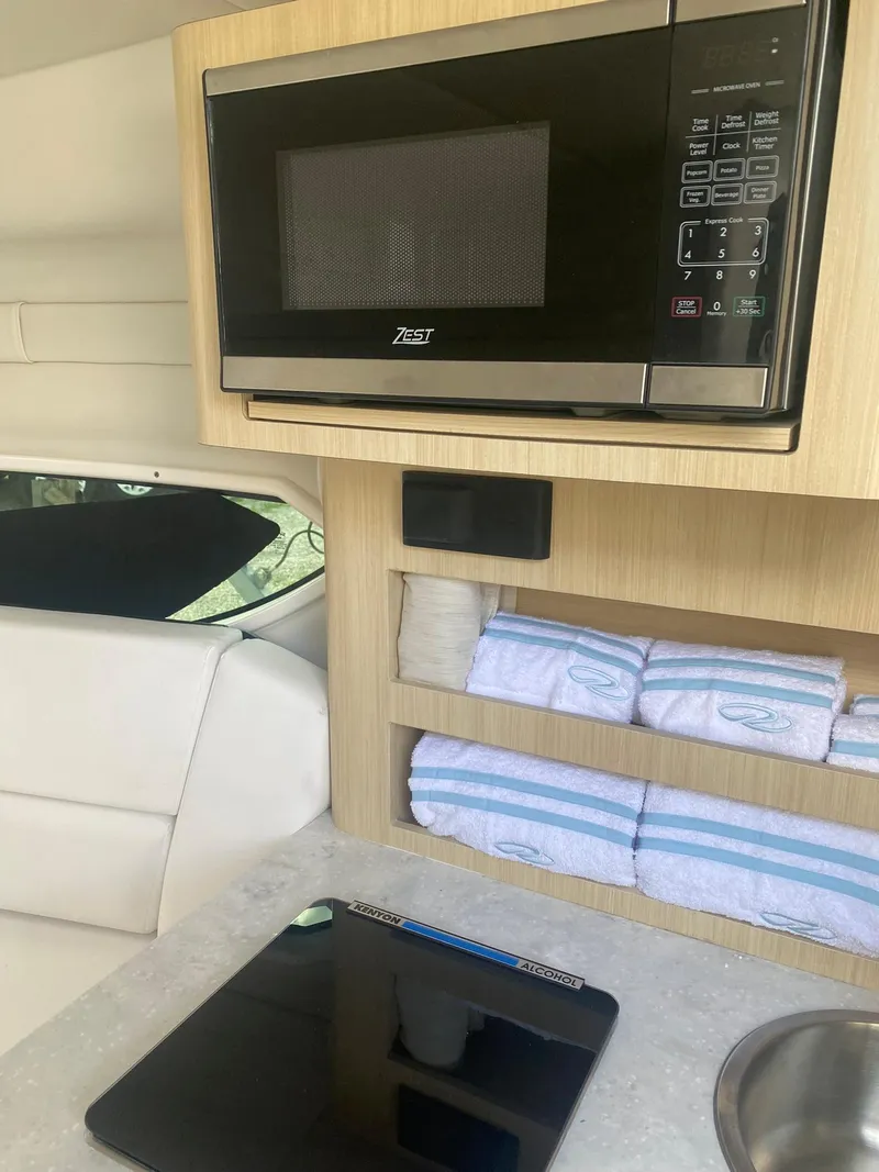 Slide: The Image of 2024 Regal 26 XO boat interior with microwave and storage shelves. - 10