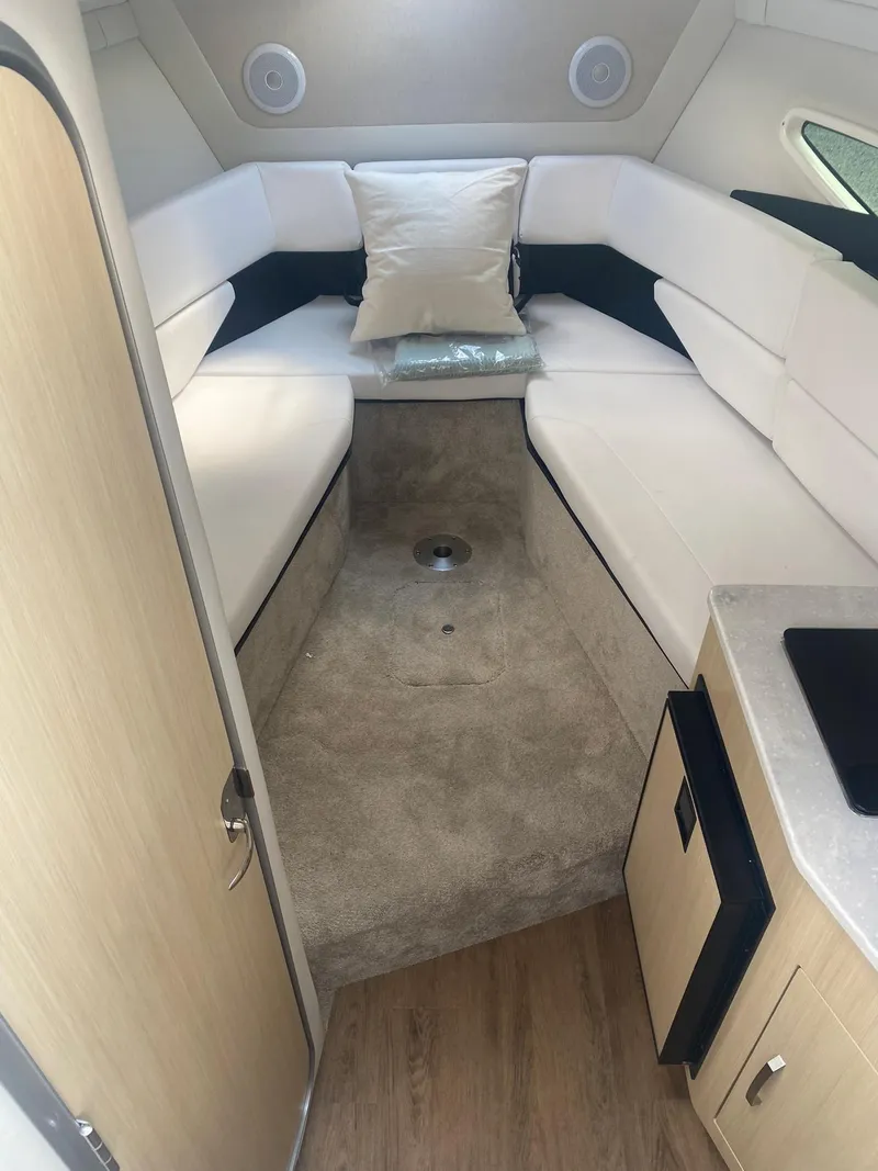 Slide: The Image of 2024 Regal 26 XO boat interior with white seating and modern amenities. - 11