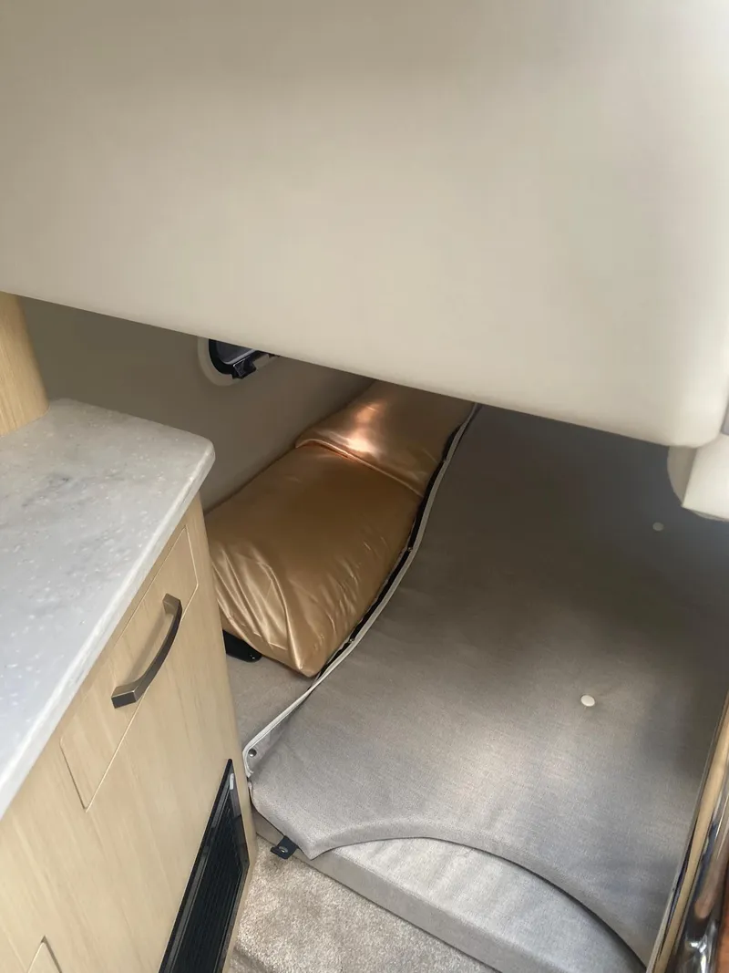 Slide: The Image of 2024 Regal 26 XO cabin interior with bed and storage. - 12