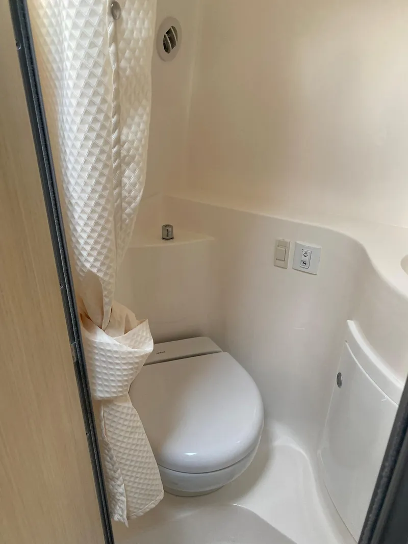 Slide: The Image of 2024 Regal 26 XO boat bathroom with toilet and shower curtain. - 13