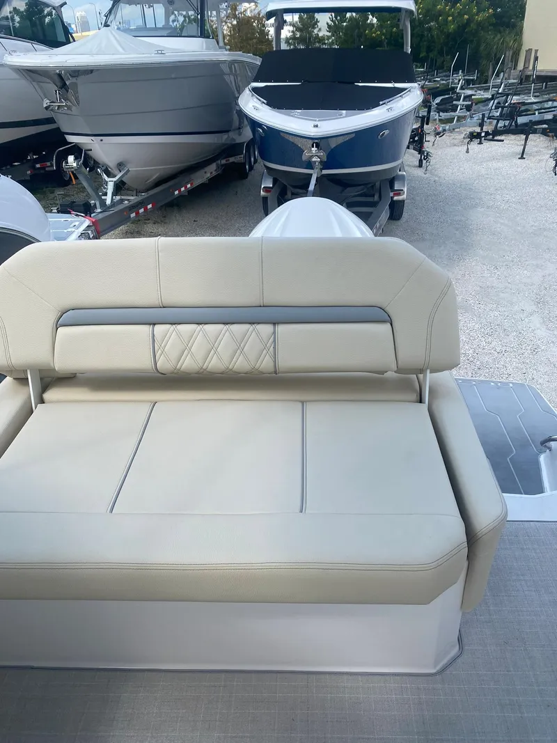 Slide: The Image of 2024 Regal 26 XO boat with beige seating, docked among other boats. - 5