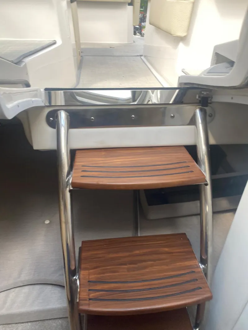 Slide: The Image of 2024 Regal 26 XO boat interior with wooden steps and stainless steel handrails. - 9