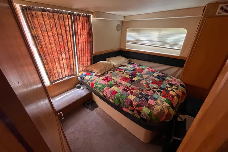 Slide: The Image of Cozy bedroom in 1996 Carver 400 Cockpit Motor Yacht with colorful quilt and window blinds. - 15