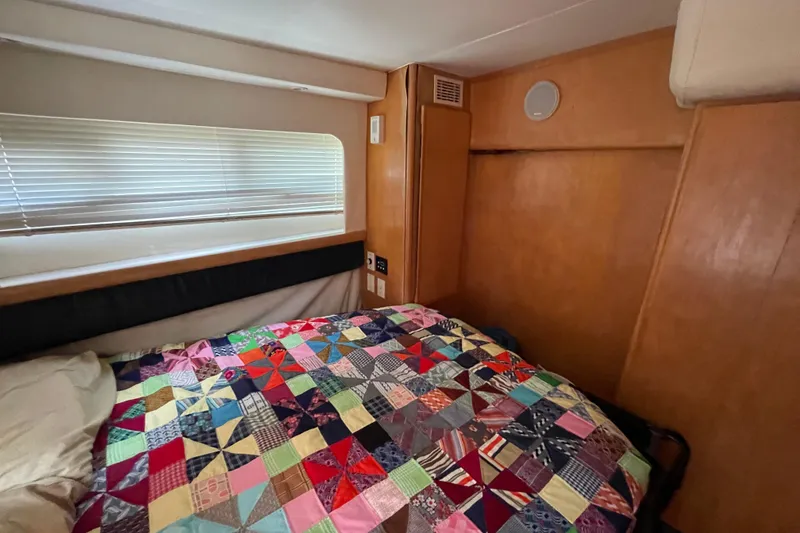 Slide: The Image of Cozy cabin interior of 1996 Carver 400 Cockpit Motor Yacht with colorful patchwork quilt. - 16