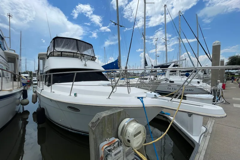 Slide: The Image of 1996 Carver 400 Cockpit Motor Yacht docked at marina under blue sky. - 2