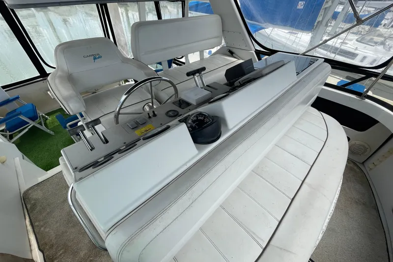 Slide: The Image of 1996 Carver 400 Cockpit Motor Yacht helm with steering wheel and controls. - 4