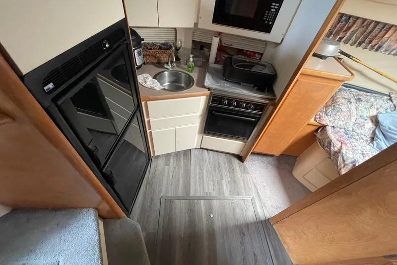 Slide: The Image of Interior of 1996 Carver 400 Cockpit Motor Yacht with kitchen and cozy sleeping area. - 11