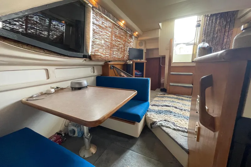 Slide: The Image of Interior of 1996 Carver 400 Cockpit Motor Yacht with dining area and cozy seating. - 14