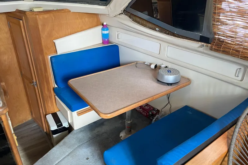 Slide: The Image of Interior of 1996 Carver 400 Cockpit Motor Yacht with blue seating and table. - 21
