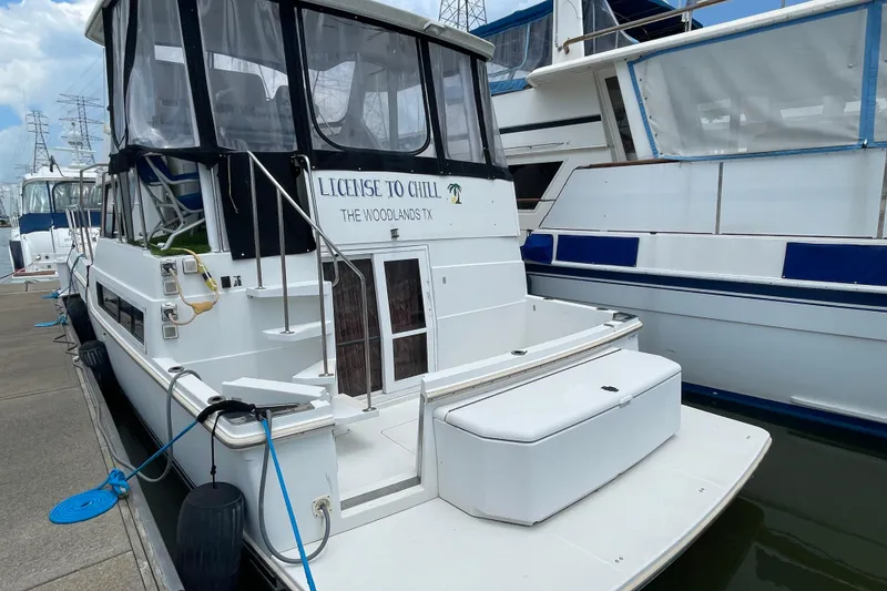 Slide: The Image of 1996 Carver 400 Cockpit Motor Yacht docked, featuring "License to Chill" signage. - 3