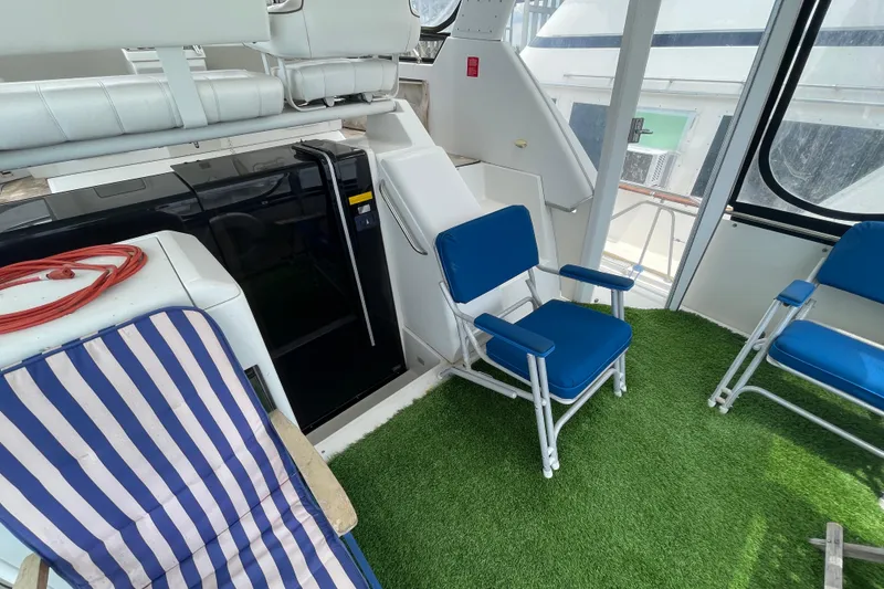 Slide: The Image of 1996 Carver 400 Cockpit Motor Yacht interior with blue chairs and striped lounge chair. - 7