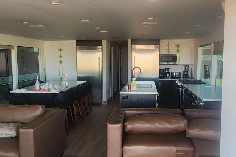 Slide: The Image of Modern kitchen interior in Adonia Legacy Share #8, 2022, featuring sleek appliances and leather seating. - 10