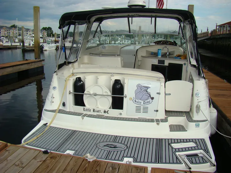 Slide: The Image of 2002 Rinker 342 Fiesta Vee boat docked at marina, rear view with open cockpit. - 2