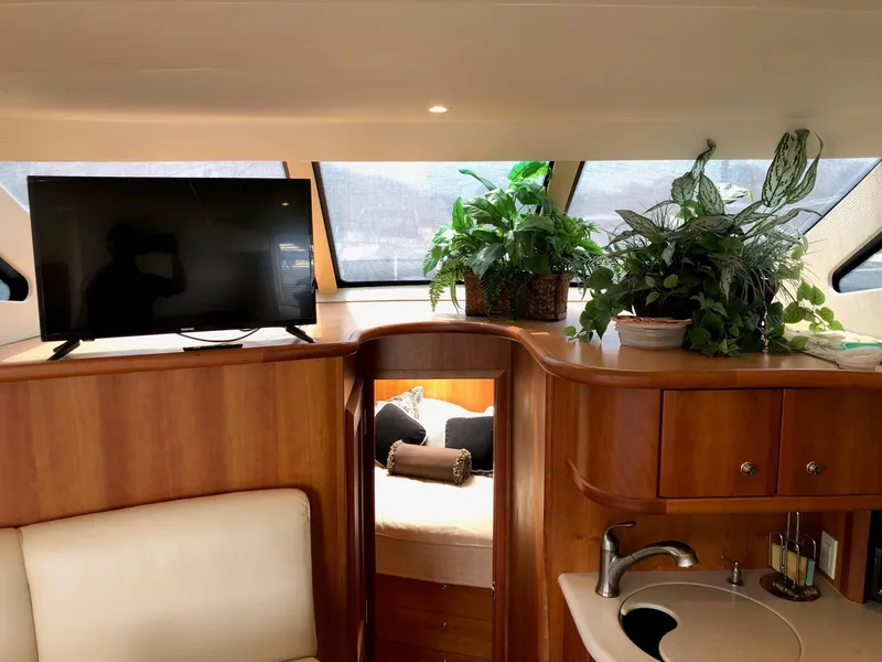 Slide: The Image of Interior of 2003 Silverton 35 Motor Yacht with TV, plants, and cozy cabin. - 19