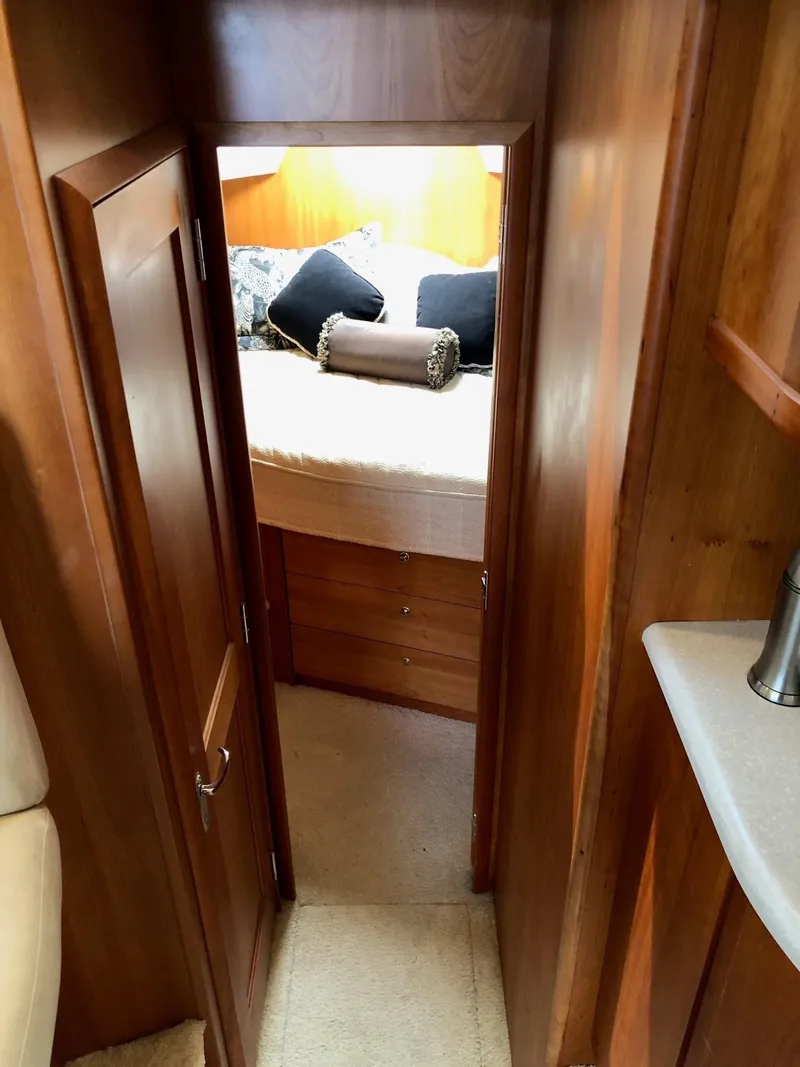 Slide: The Image of 2003 Silverton 35 Motor Yacht interior cabin with bed and wooden finish. - 20