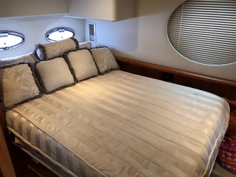 Slide: The Image of Luxurious bedroom in a 2003 Silverton 35 Motor Yacht with elegant bedding and porthole windows. - 25