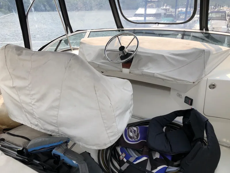 Slide: The Image of 2003 Silverton 35 Motor Yacht helm with covered seats and steering wheel. - 8