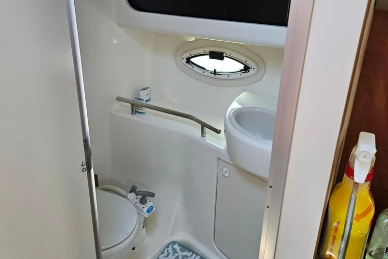 Slide: The Image of 2006 Bayliner 305 boat bathroom with toilet, sink, and porthole window. - 10
