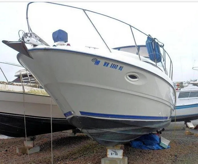Slide: The Image of 2006 Bayliner 305 boat on dry dock, white hull with blue accents. - 16